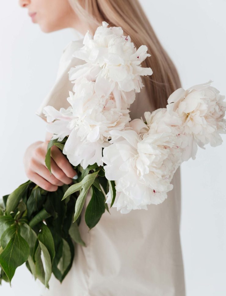 blonde-woman-standing-isolated-holding-flowers-P8B3XEP-1-scaled.jpg